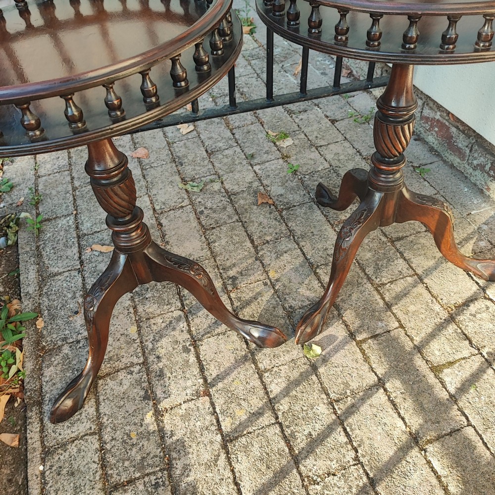 A pair of dark mahogany tripod tables featuring circular tops with spindle galleries, turned shafts, and carved cabriole legs with claw and ball feet. View V