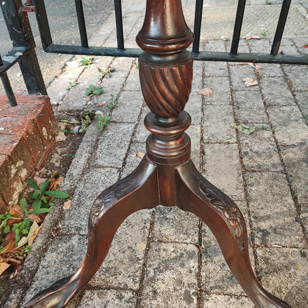 A pair of dark mahogany tripod tables featuring circular tops with spindle galleries, turned shafts, and carved cabriole legs with claw and ball feet. View VI