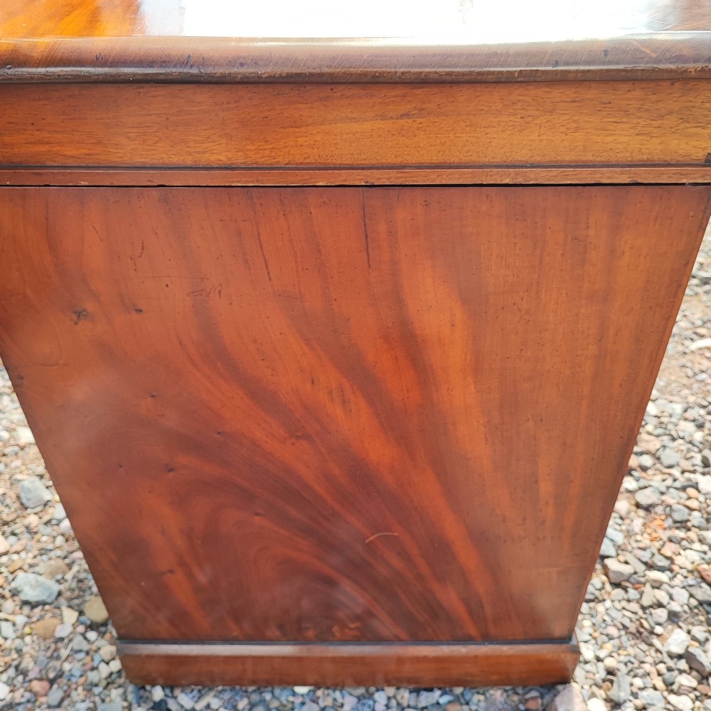An antique mahogany pedestal desk featuring eight drawers with turned wooden knobs and a polished rectangular top surface. View VIII