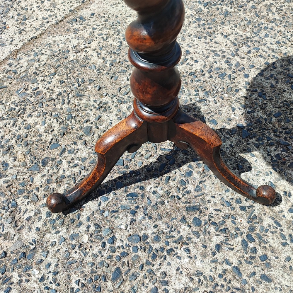 A small circular mahogany wine table with a green leather inset top supported by a turned pedestal column on three cabriole legs. View III