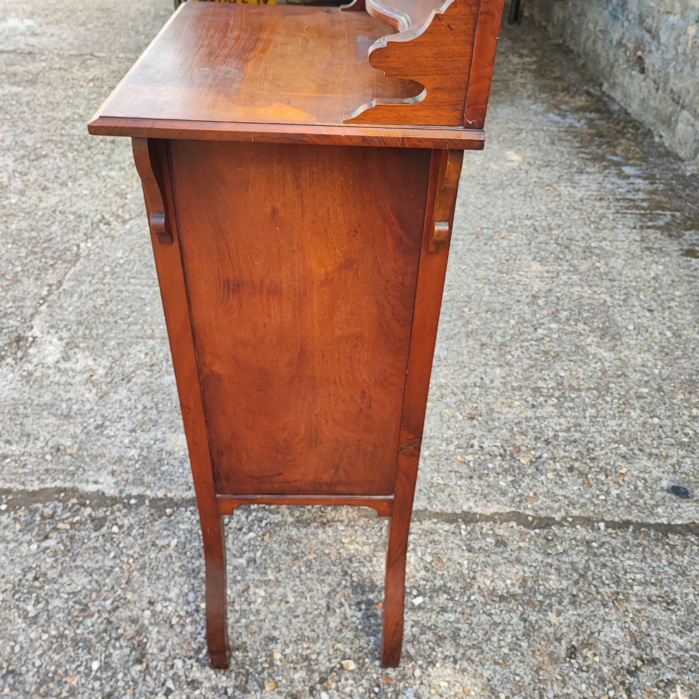 A narrow Victorian mahogany standing dressing table featuring an integrated swivel mirror above a single drawer, storage cupboard, and curved legs. View VI