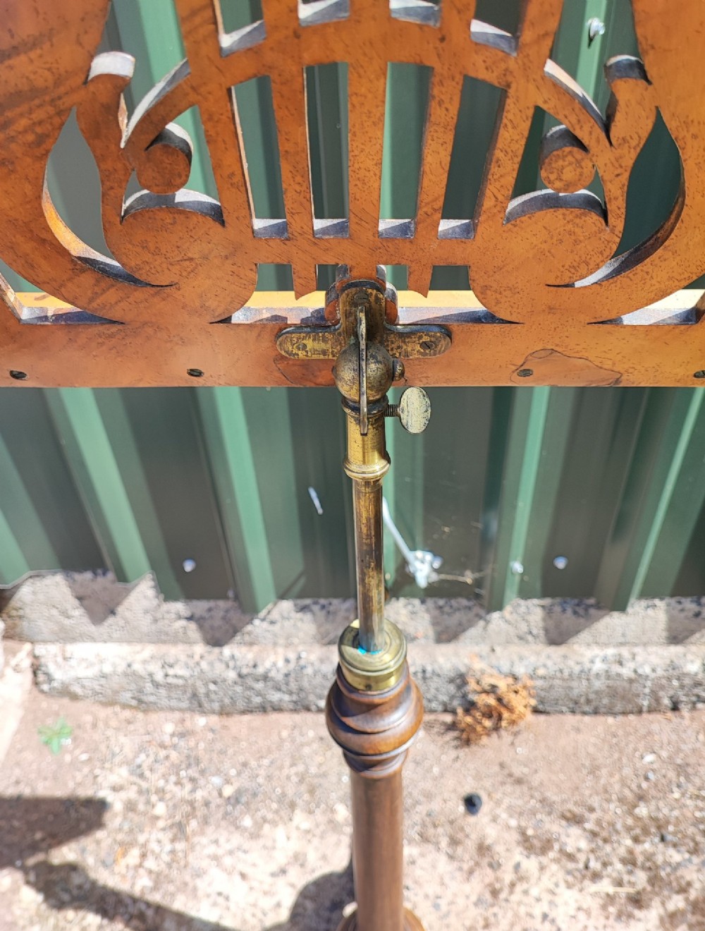 A Victorian walnut music stand featuring a fretwork lyre rest, height-adjustable brass stem, turned column, and carved tripod legs. View III