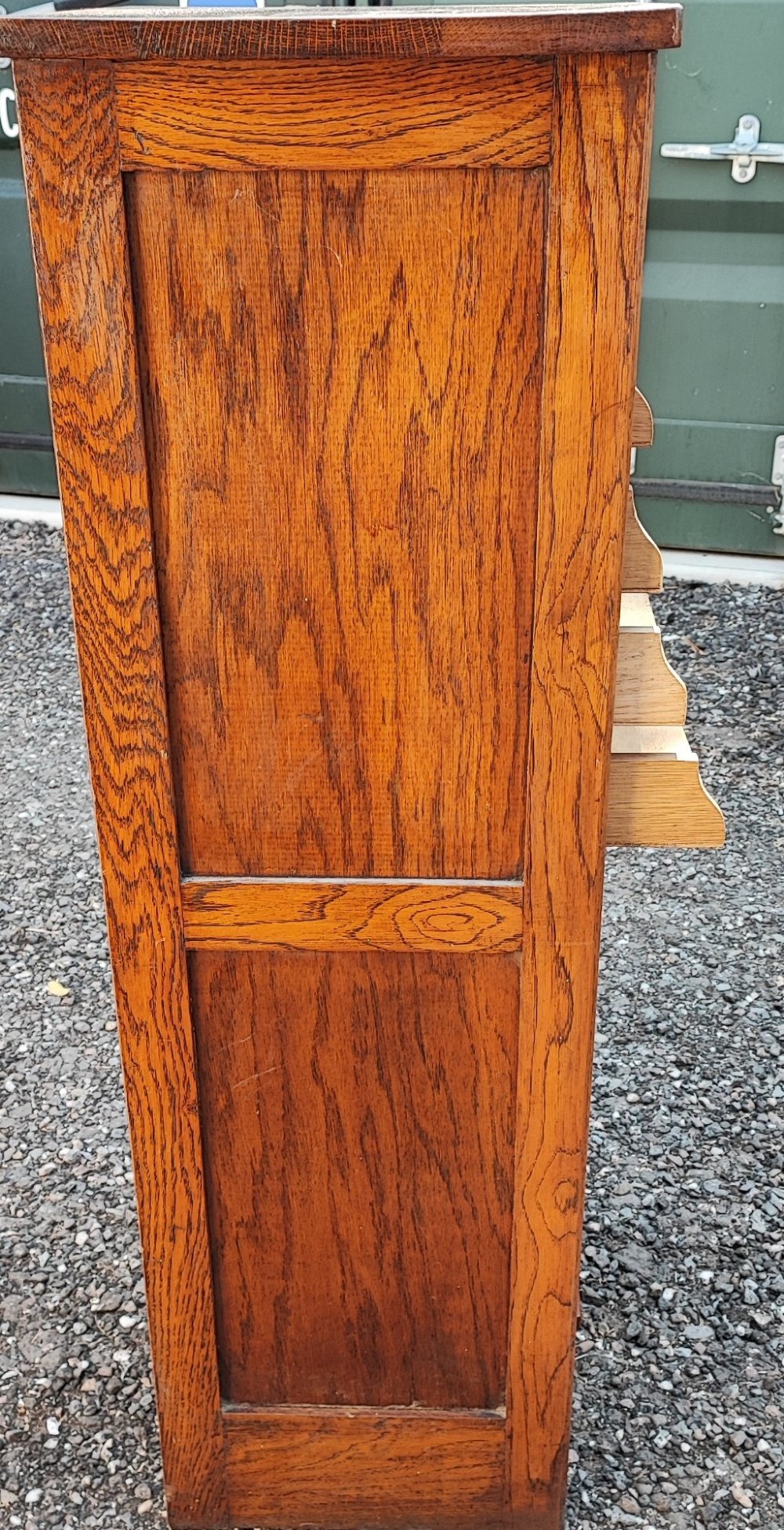 A tall Edwardian oak filing cabinet featuring a slatted wooden tambour front shutter, keyhole escutcheon with key, and wooden pull handles. View V