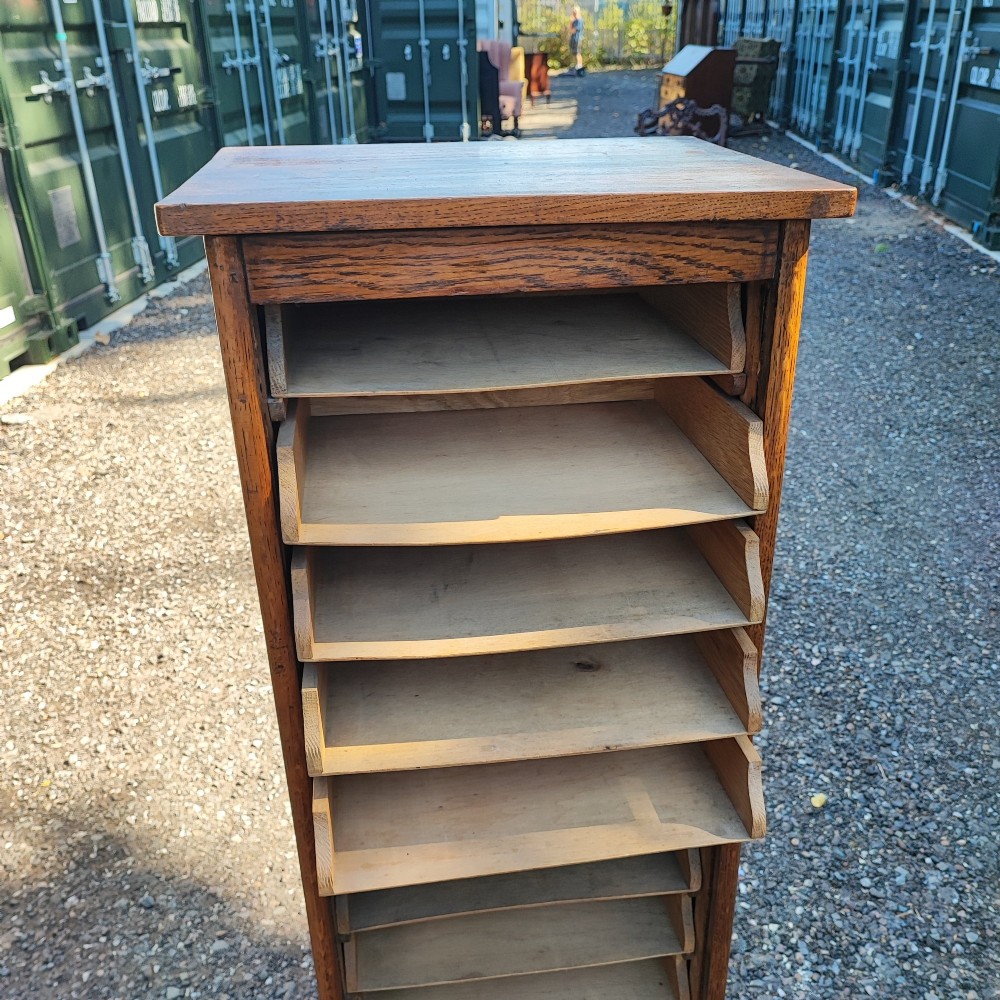 A tall Edwardian oak filing cabinet featuring a slatted wooden tambour front shutter, keyhole escutcheon with key, and wooden pull handles. View VI