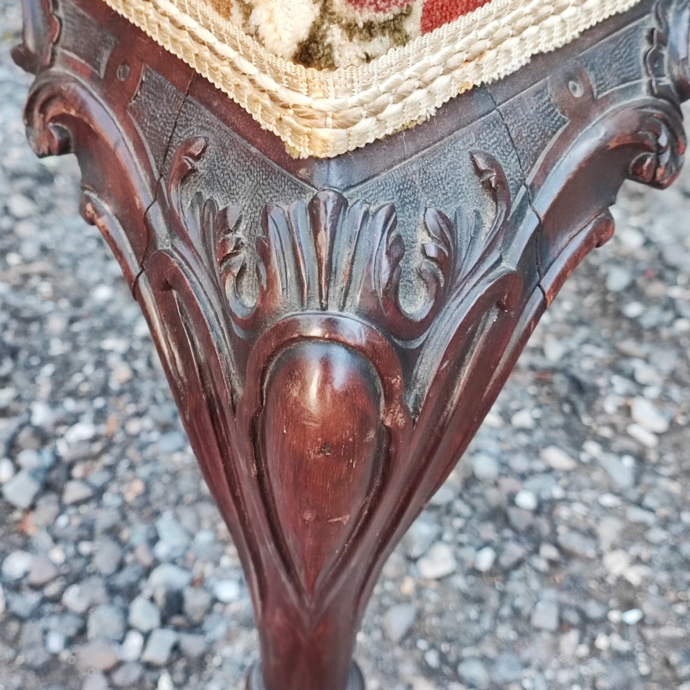 An antique carved mahogany Chippendale style armchair featuring an intricate ribbon-back splat, carved armrests, floral pattern fabric seat, and cabriole legs with ball-and-claw feet. View III
