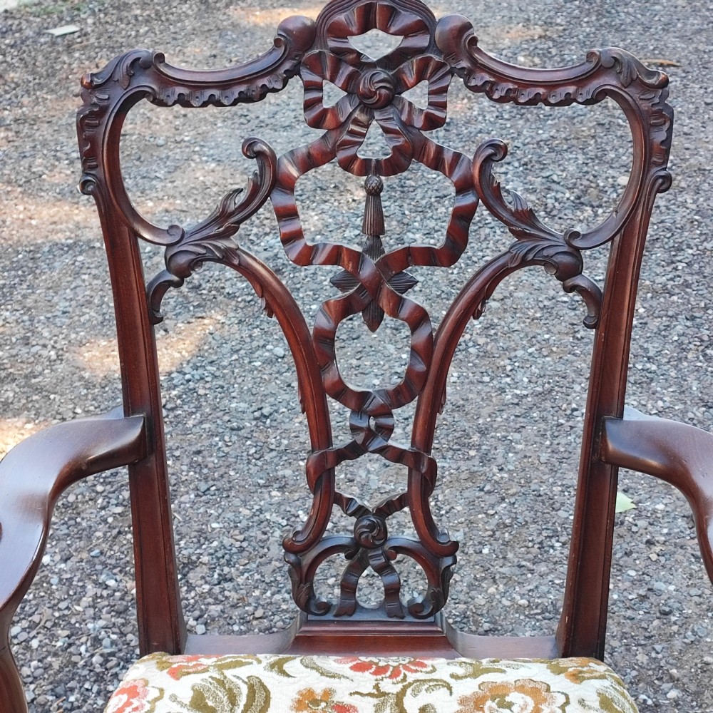 An antique carved mahogany Chippendale style armchair featuring an intricate ribbon-back splat, carved armrests, floral pattern fabric seat, and cabriole legs with ball-and-claw feet. View IV