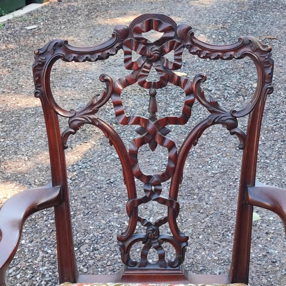 An antique carved mahogany Chippendale style armchair featuring an intricate ribbon-back splat, carved armrests, floral pattern fabric seat, and cabriole legs with ball-and-claw feet. View VII