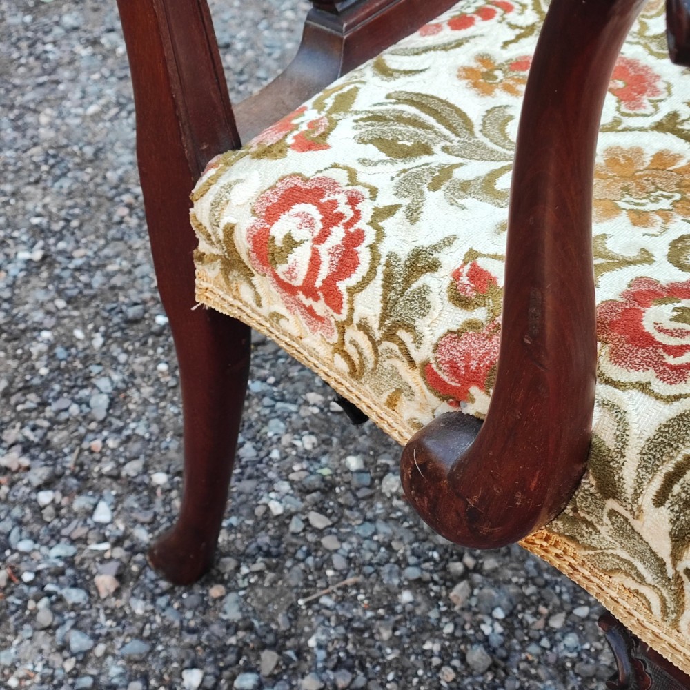 An antique carved mahogany Chippendale style armchair featuring an intricate ribbon-back splat, carved armrests, floral pattern fabric seat, and cabriole legs with ball-and-claw feet. View VIII