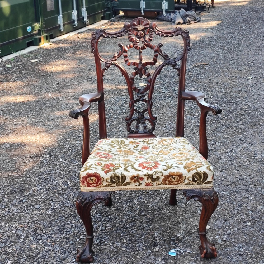 An antique carved mahogany Chippendale style armchair featuring an intricate ribbon-back splat, carved armrests, floral pattern fabric seat, and cabriole legs with ball-and-claw feet. View IX