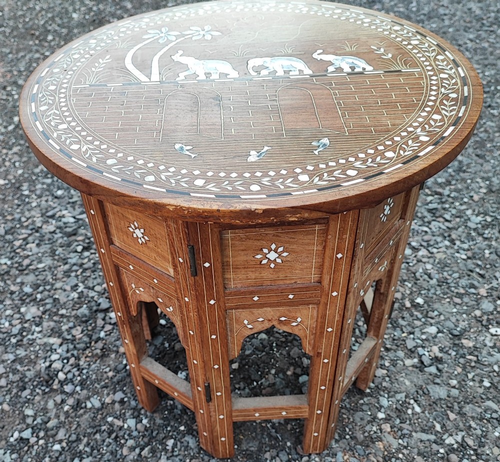 An octagonal Anglo-Indian hardwood occasional table featuring white bone inlay depicting elephants, palm trees, and floral borders.