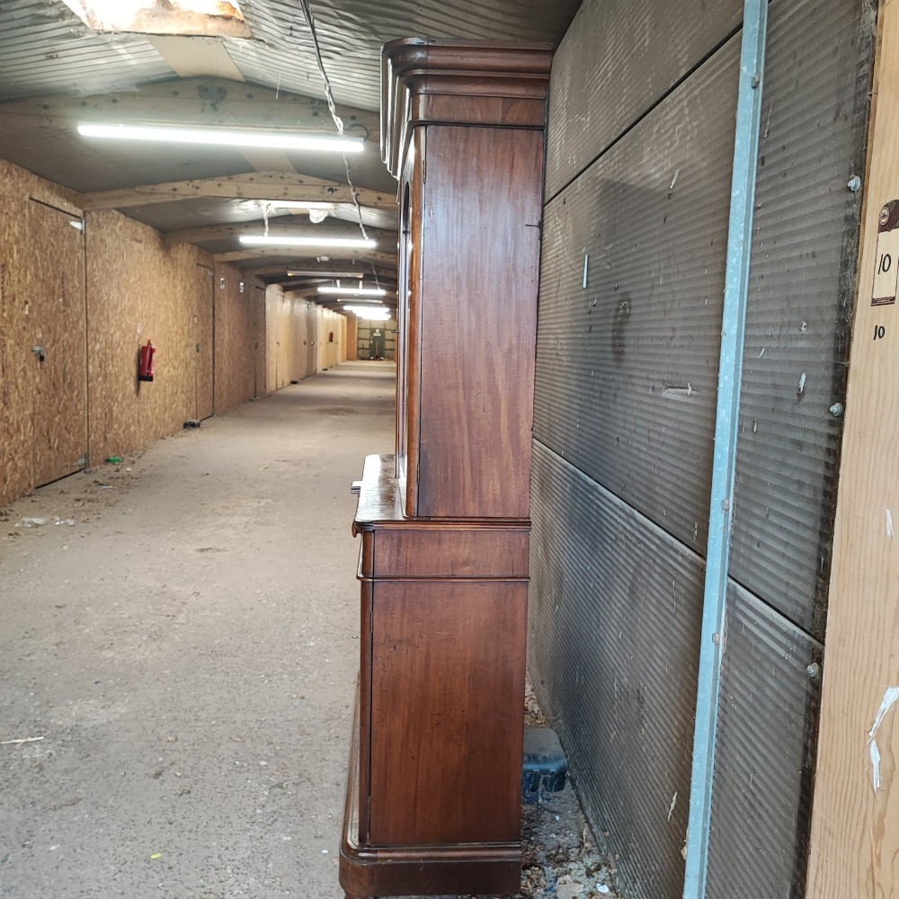 A tall Victorian mahogany bookcase featuring two glazed upper doors, two frieze drawers, and a double-door lower cupboard. View VI