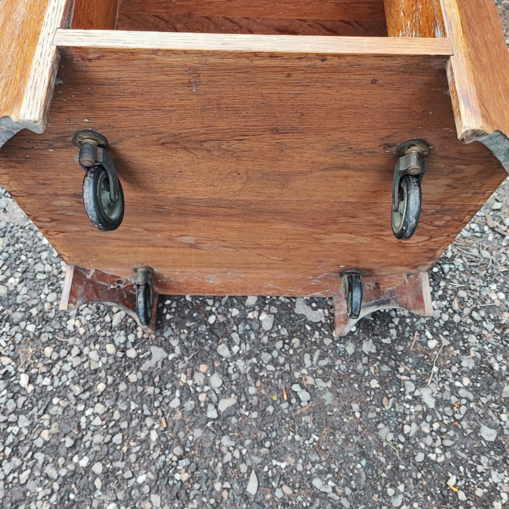 An octagonal antique oak side table featuring open lower shelves for books, showcasing quarter-sawn wood grain. View IV