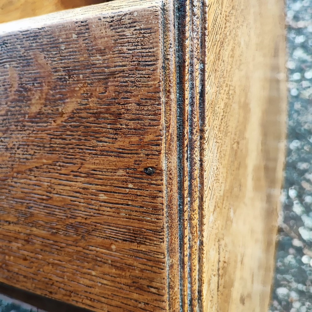 An octagonal antique oak side table featuring open lower shelves for books, showcasing quarter-sawn wood grain. View VI