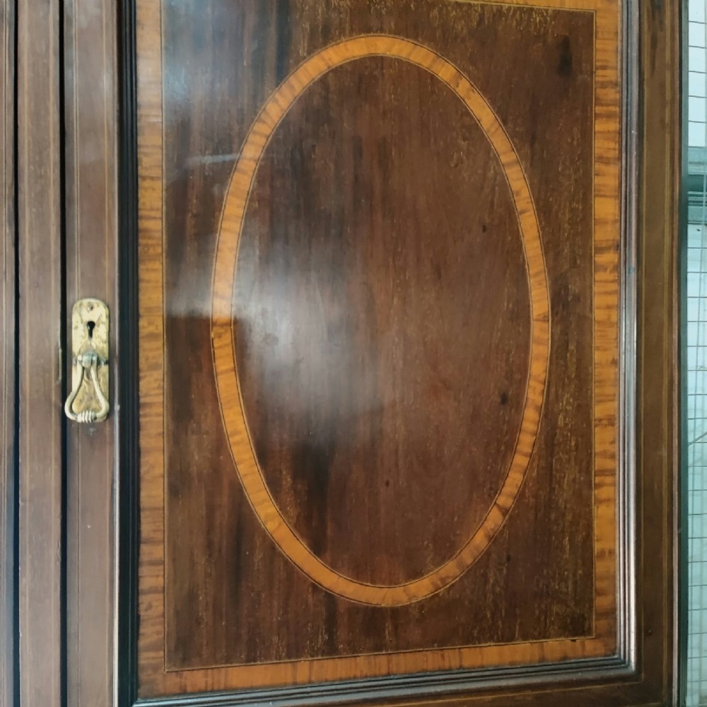 A Victorian mahogany compactum wardrobe featuring a full-length mirrored door on the left alongside a top cupboard with an oval satinwood medallion and several drawers on the right. View III