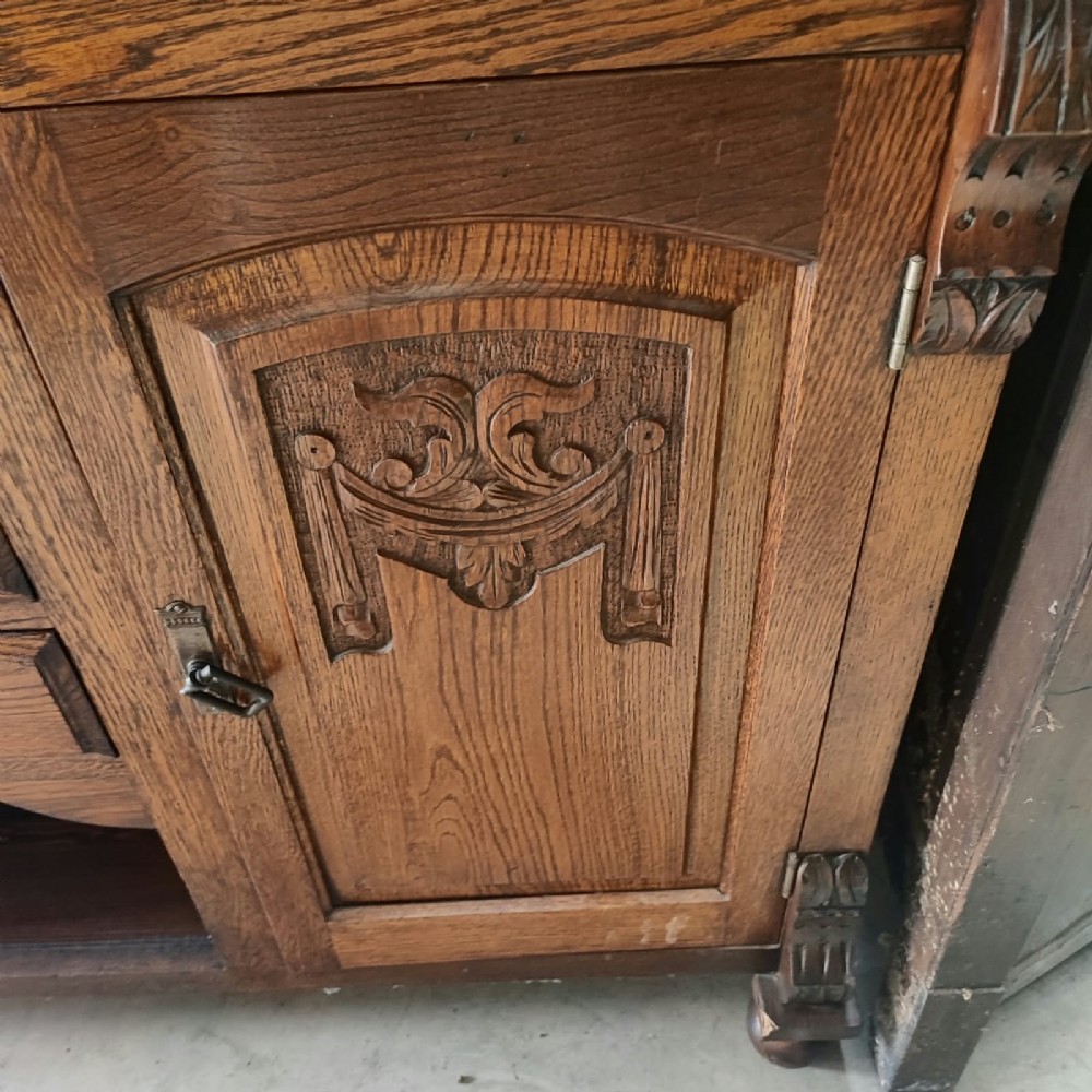 A Victorian tiger oak Welsh dresser featuring a glazed upper display rack above a base unit with carved panel doors and central drawers. View II