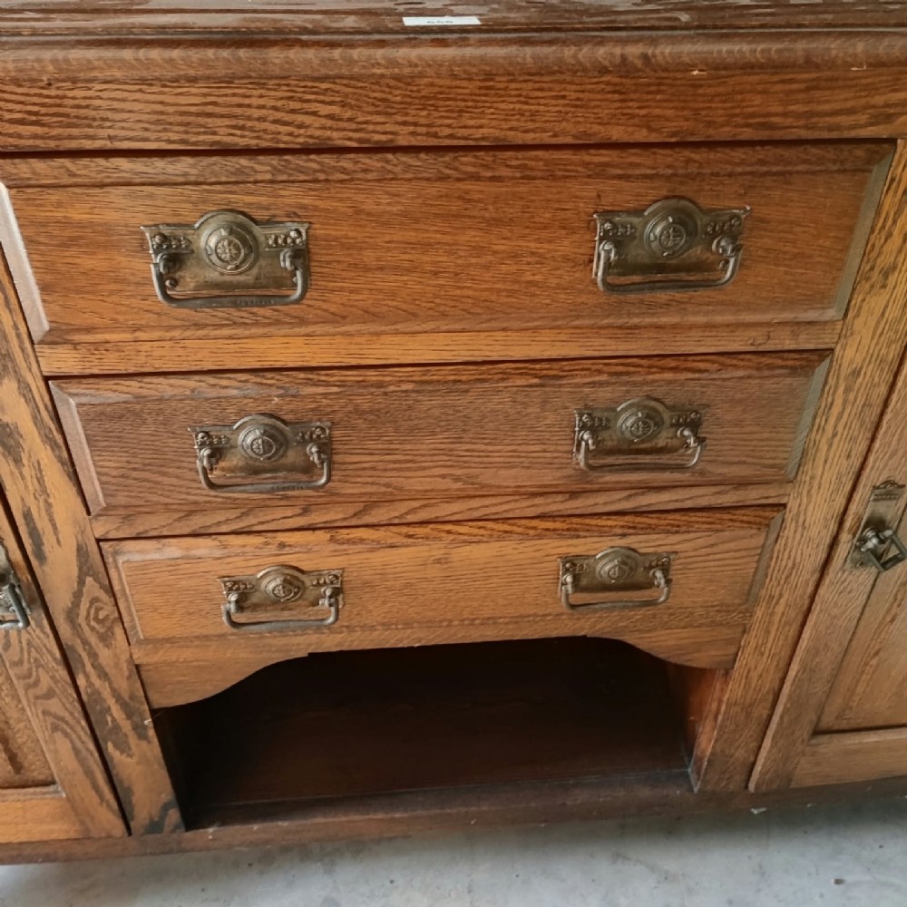 A Victorian tiger oak Welsh dresser featuring a glazed upper display rack above a base unit with carved panel doors and central drawers. View VI