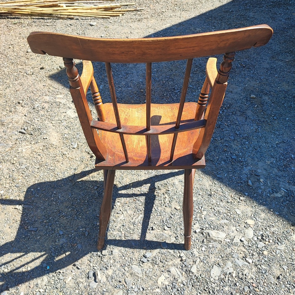 An antique wooden country armchair featuring turned front legs, a spindle backrest with a carved top rail, and curved armrests. View II