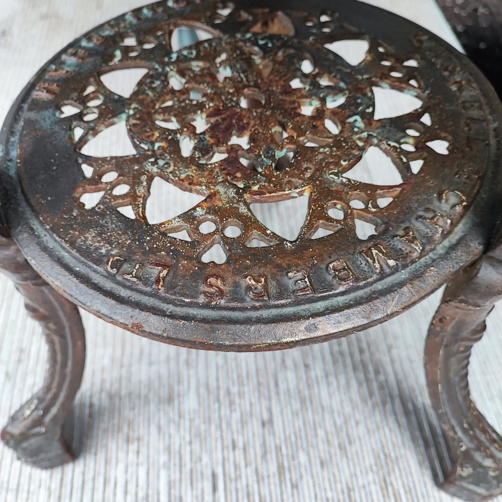 A Victorian cast iron tripod pub table featuring ornate leg castings with classical face motifs, a pierced lower circular tier, and a round wooden tabletop. View III