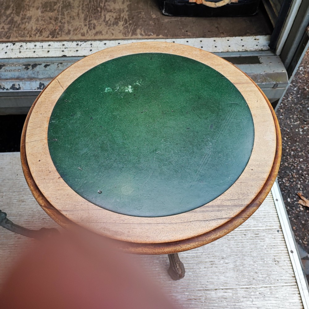 A Victorian cast iron tripod pub table featuring ornate leg castings with classical face motifs, a pierced lower circular tier, and a round wooden tabletop. View IV
