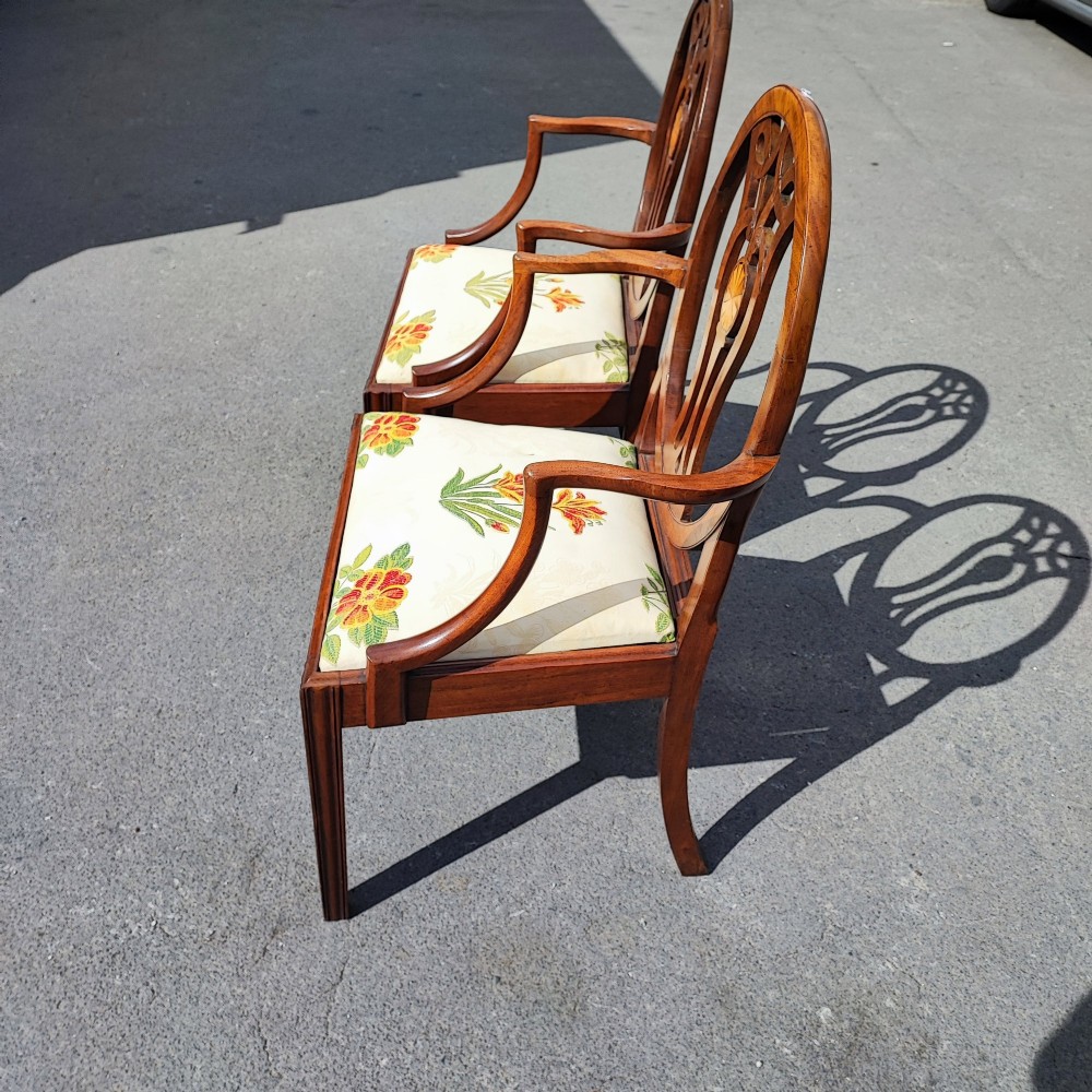 A pair of mahogany armchairs featuring oval backs with pierced splats, inlaid oval paterae, curved armrests, and floral embroidered upholstered seats. View II