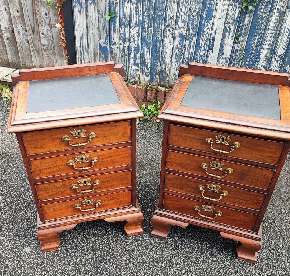 A pair of small warm brown mahogany chests of drawers featuring inset leather tops, four drawers with brass swan-neck handles, and shaped bracket feet. View III
