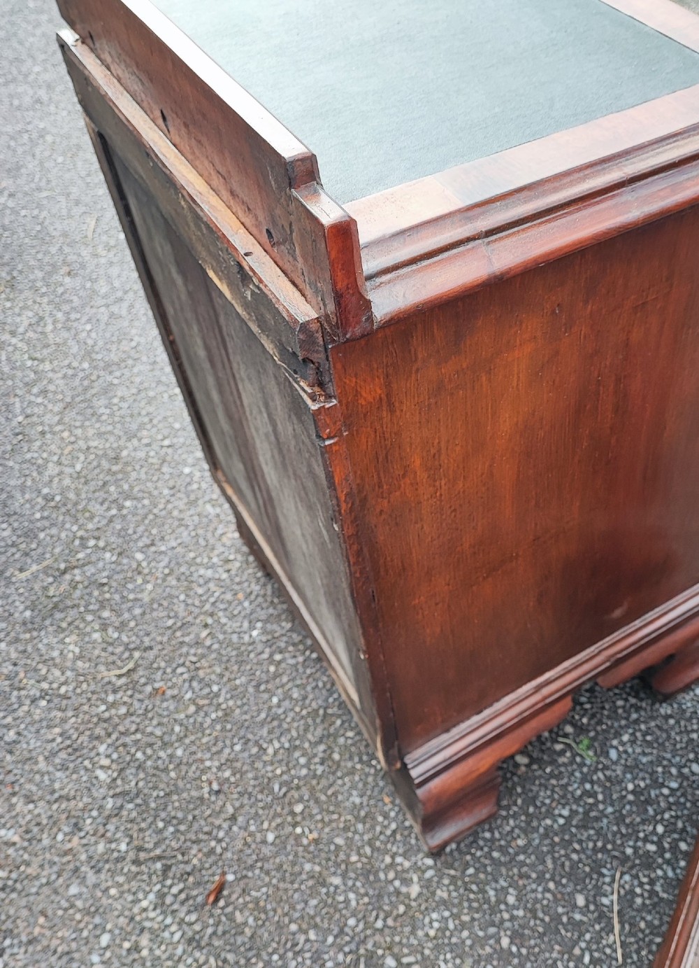 A pair of small warm brown mahogany chests of drawers featuring inset leather tops, four drawers with brass swan-neck handles, and shaped bracket feet. View VI