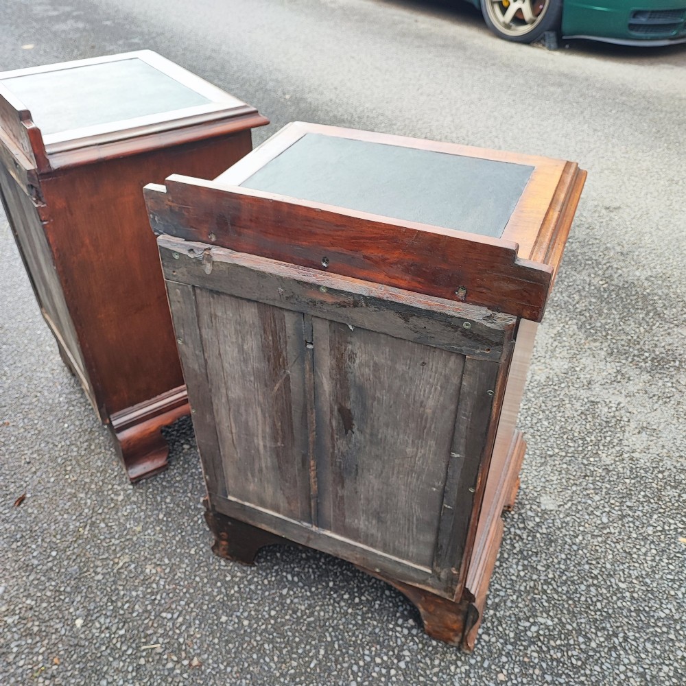 A pair of small warm brown mahogany chests of drawers featuring inset leather tops, four drawers with brass swan-neck handles, and shaped bracket feet. View IX