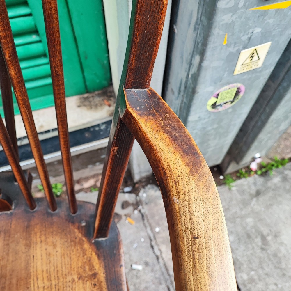 A pair of antique wooden Windsor armchairs featuring pierced wheelback splats, curved arms, shaped saddle seats, and turned legs. View III