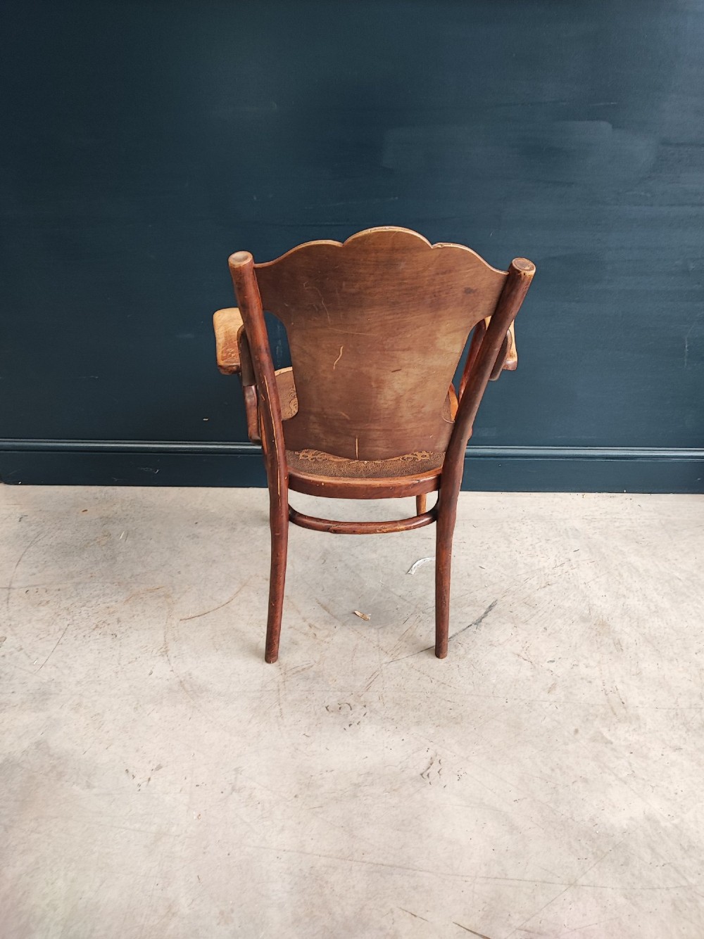A bentwood beechwood armchair featuring curved armrests and embossed Art Nouveau scrollwork on the plywood seat and backrest. View III