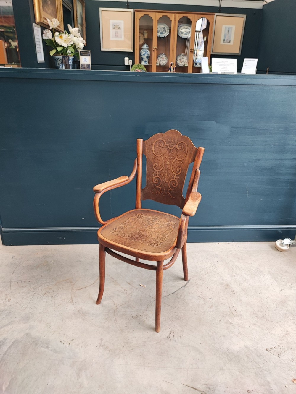 A bentwood beechwood armchair featuring curved armrests and embossed Art Nouveau scrollwork on the plywood seat and backrest. View IV