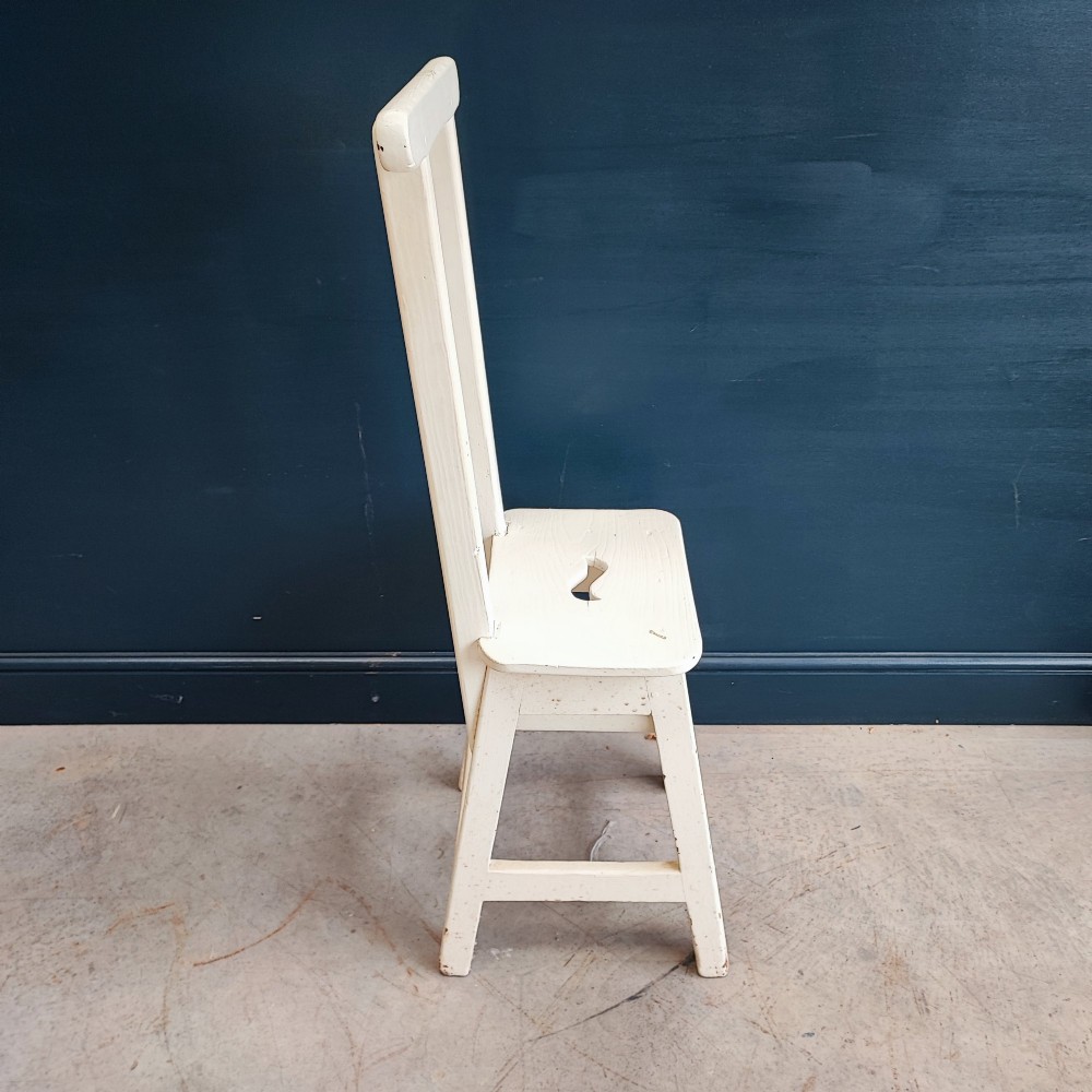 An off-white painted wooden step stool featuring a tall vertical back handle, splayed square legs, and a seat with a central carved handhole. View III
