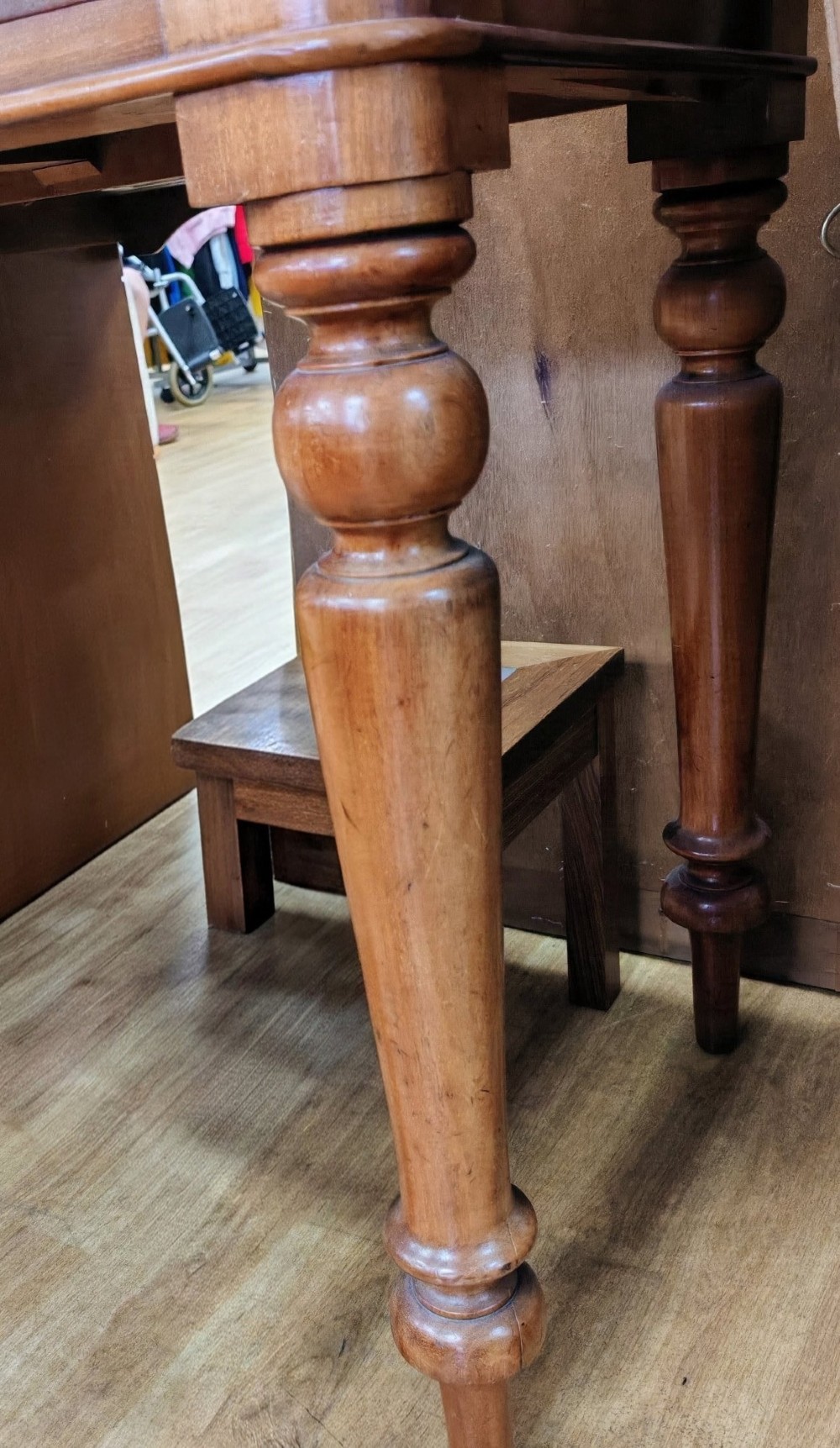A Victorian mahogany writing table featuring a rectangular top with a low raised edge, two frieze drawers with turned wooden knobs, and turned legs. View VI