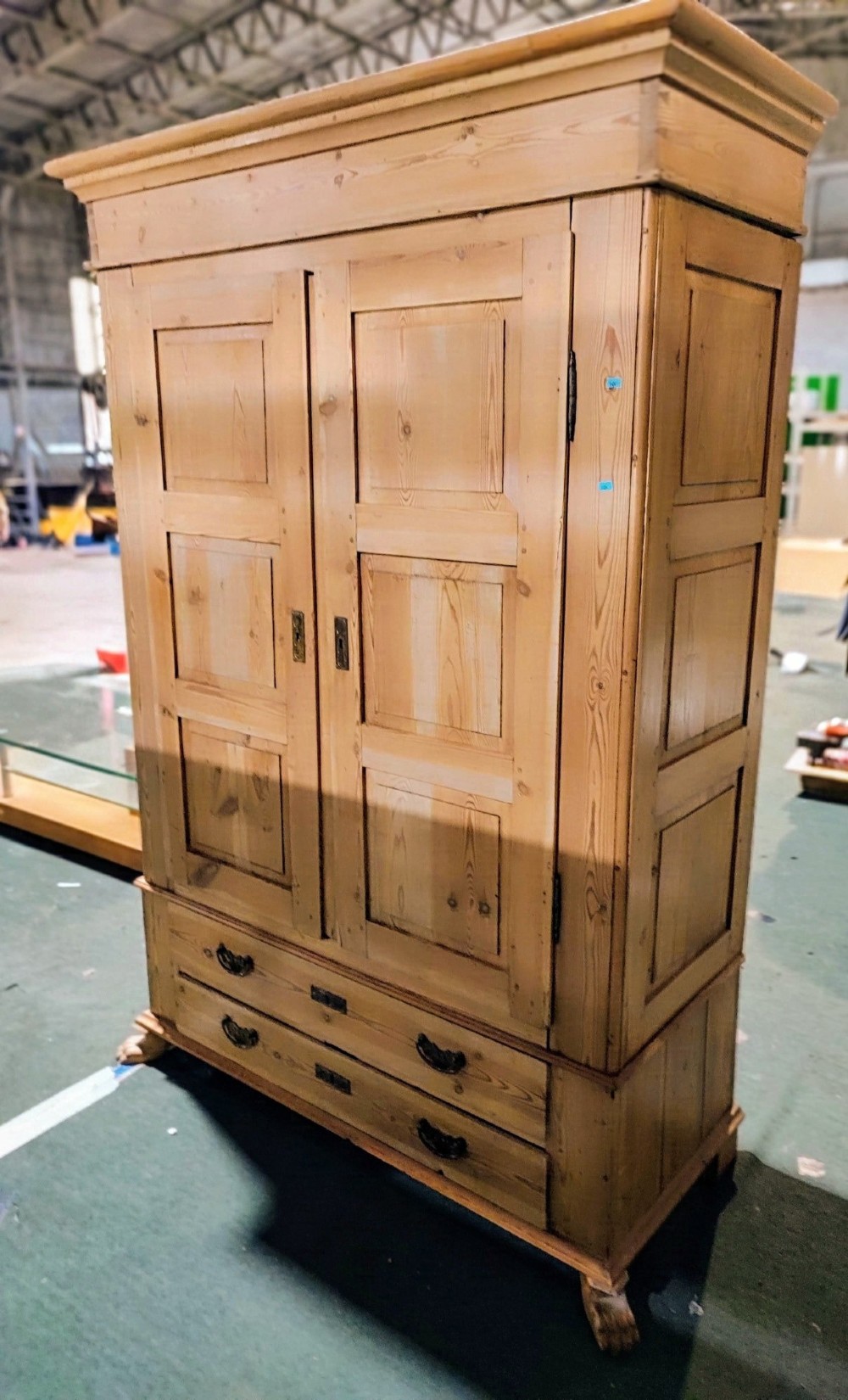 A tall antique pine two-door wardrobe featuring raised fielded panels, a moulded cornice, and two drawers at the base. View II