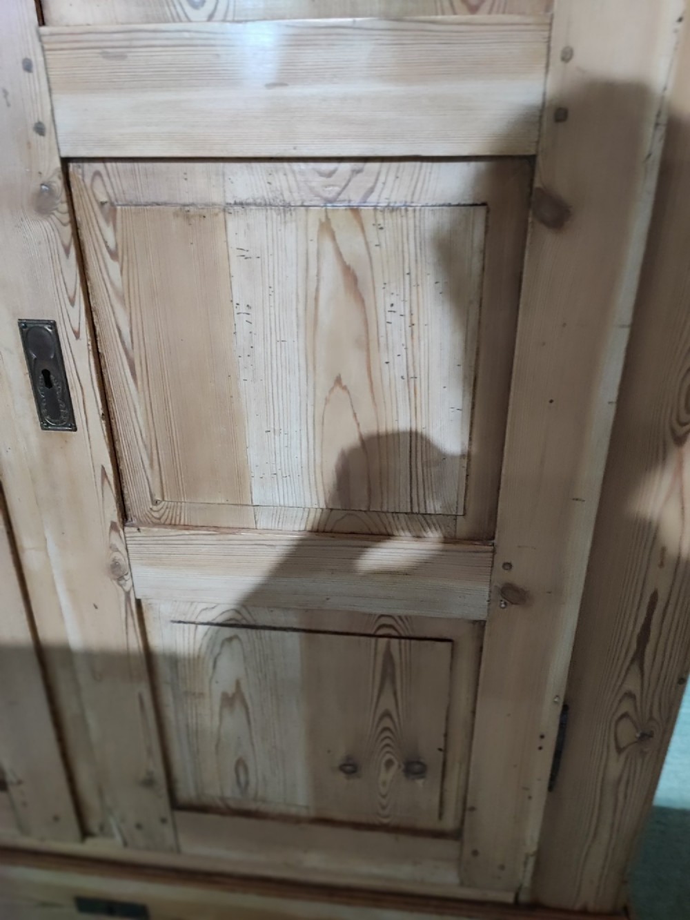 A tall antique pine two-door wardrobe featuring raised fielded panels, a moulded cornice, and two drawers at the base. View IV