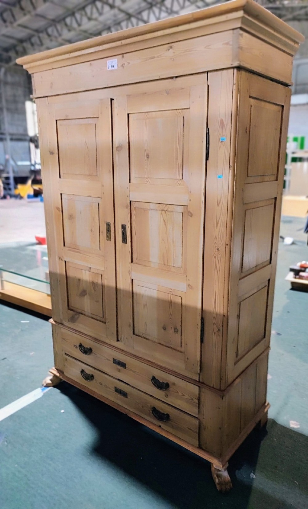 A tall antique pine two-door wardrobe featuring raised fielded panels, a moulded cornice, and two drawers at the base. View VI