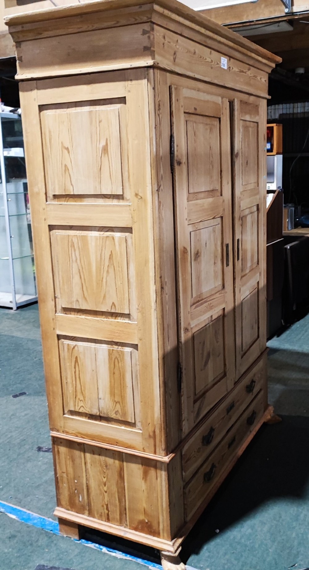 A tall antique pine two-door wardrobe featuring raised fielded panels, a moulded cornice, and two drawers at the base. View VII