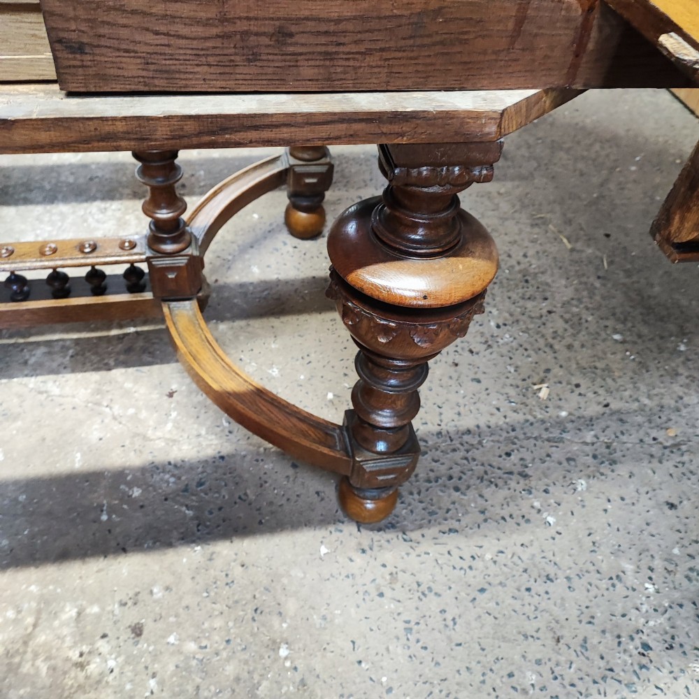 A large Victorian golden oak extending dining table featuring an oval top, carved rope-twist frieze, and elaborate turned legs joined by a central stretcher. View IX