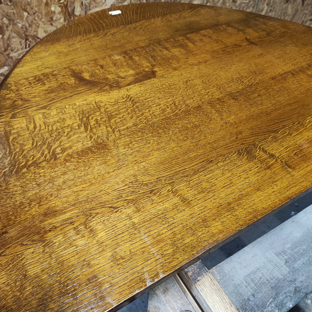 A large Victorian golden oak extending dining table featuring an oval top, carved rope-twist frieze, and elaborate turned legs joined by a central stretcher. View XII