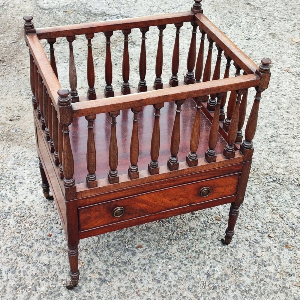 An antique Regency mahogany book trough with turned spindle sides, a single lower drawer with brass handles, and turned legs supported on brass castors. View VIII