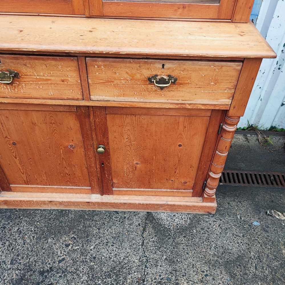 A two-piece stripped pine dresser featuring a glazed upper display cabinet with two doors and a lower section with two drawers above twin cupboard doors. View IV