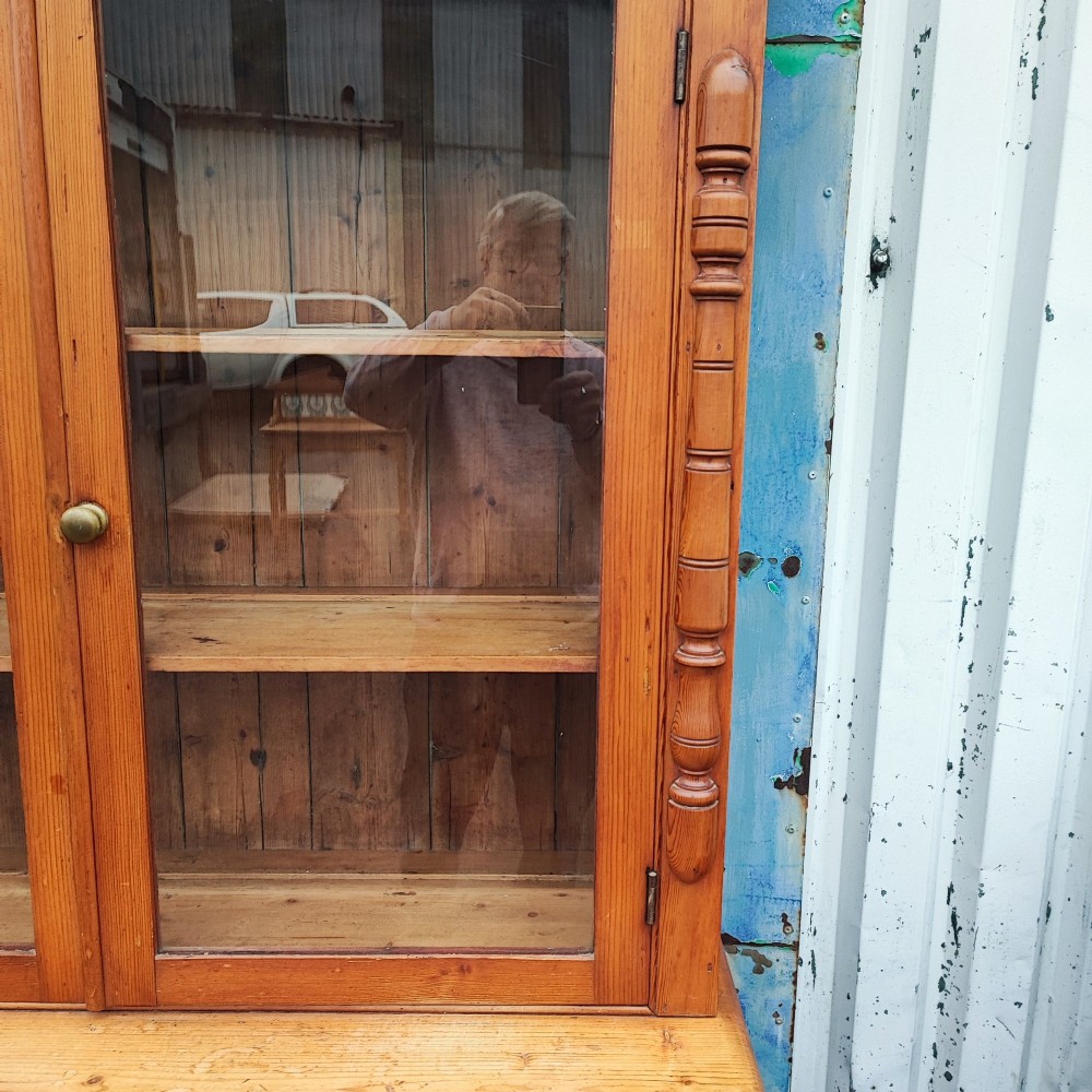 A two-piece stripped pine dresser featuring a glazed upper display cabinet with two doors and a lower section with two drawers above twin cupboard doors. View V