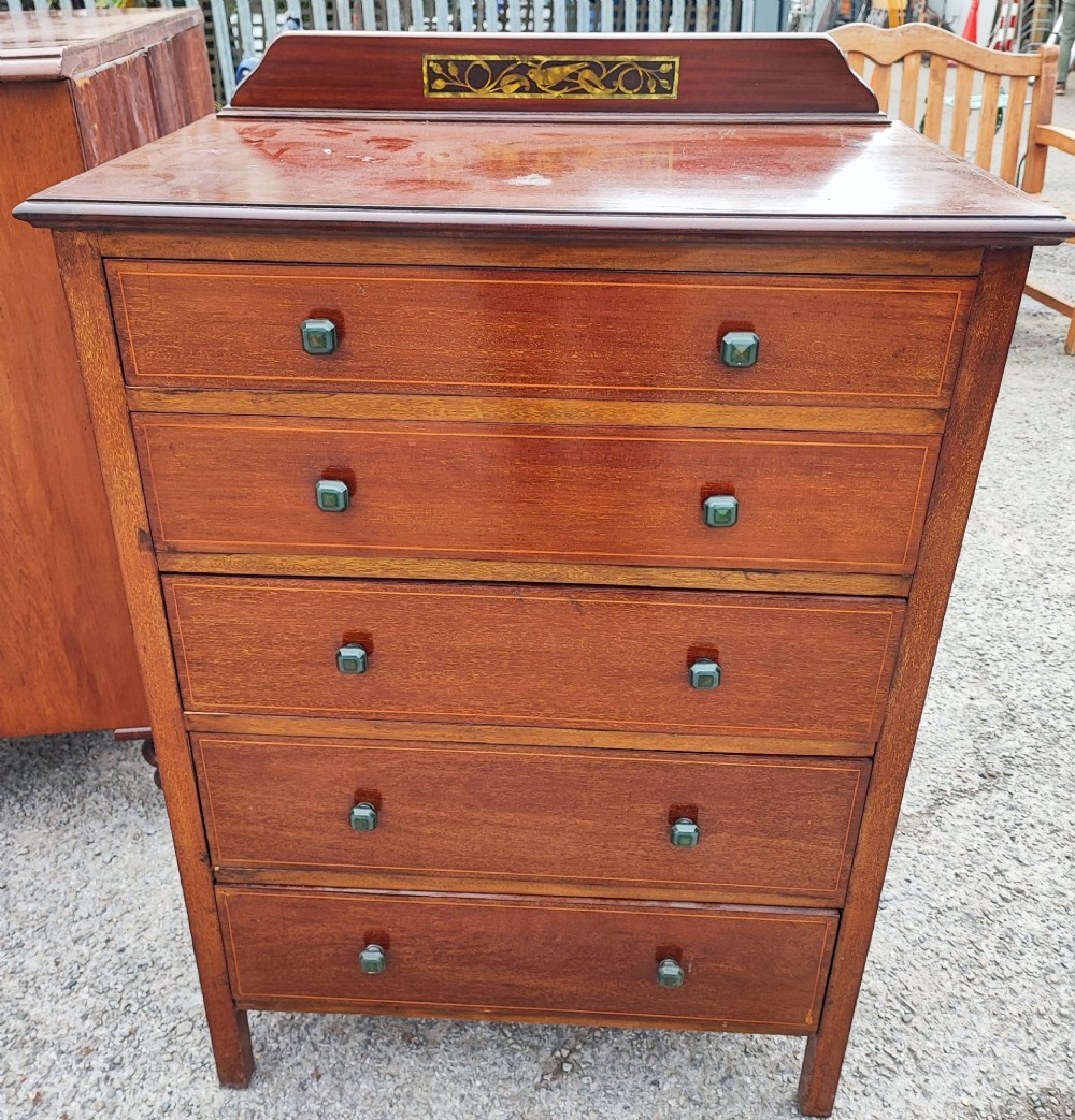 A five-drawer mahogany chest of drawers featuring boxwood line inlay, square handles, and a raised top gallery with an inlaid marquetry panel.