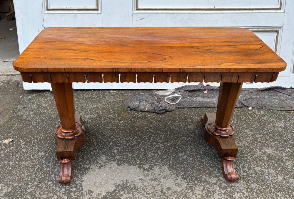 A rectangular antique rosewood window table featuring a highly figure-grained top, a scalloped frieze with drop pendants, and twin carved pedestal supports on lotus trestle feet. View III
