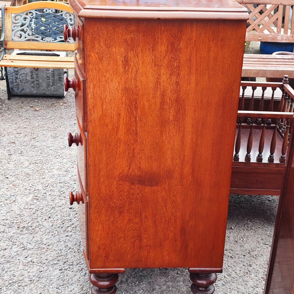 A Victorian mahogany bowfront chest of drawers with two short over three long drawers, turned wooden knobs, and turned feet. View II