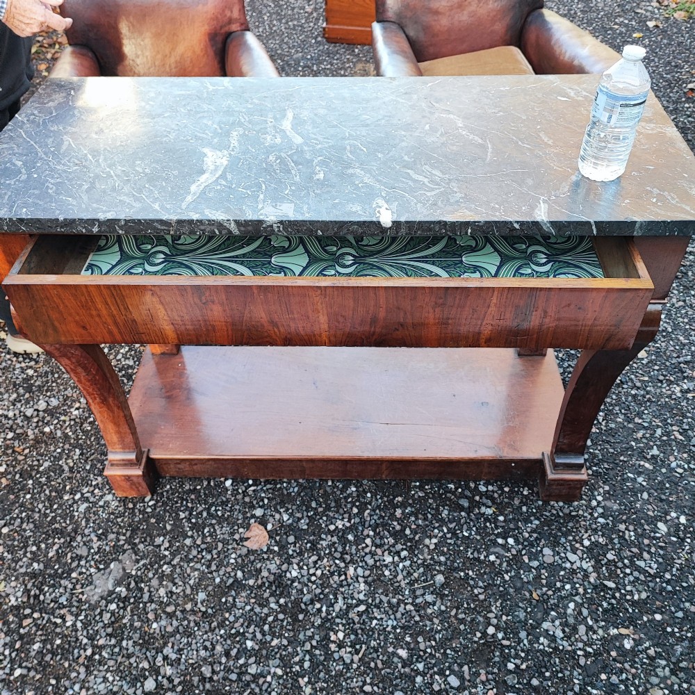 An antique French walnut console table featuring a thick grey veined marble top, scrolled front supports, and a lower plinth undertier. View V