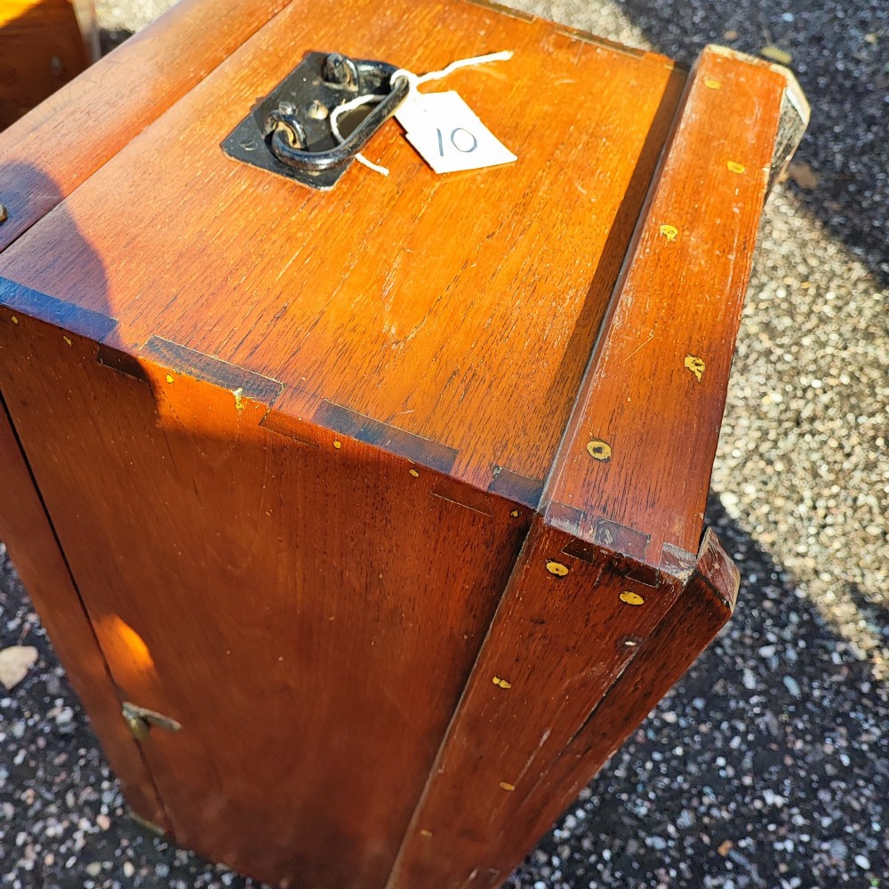 A rectangular warm brown teak sea chest featuring reinforced brass corner brackets and dovetail joinery. View X