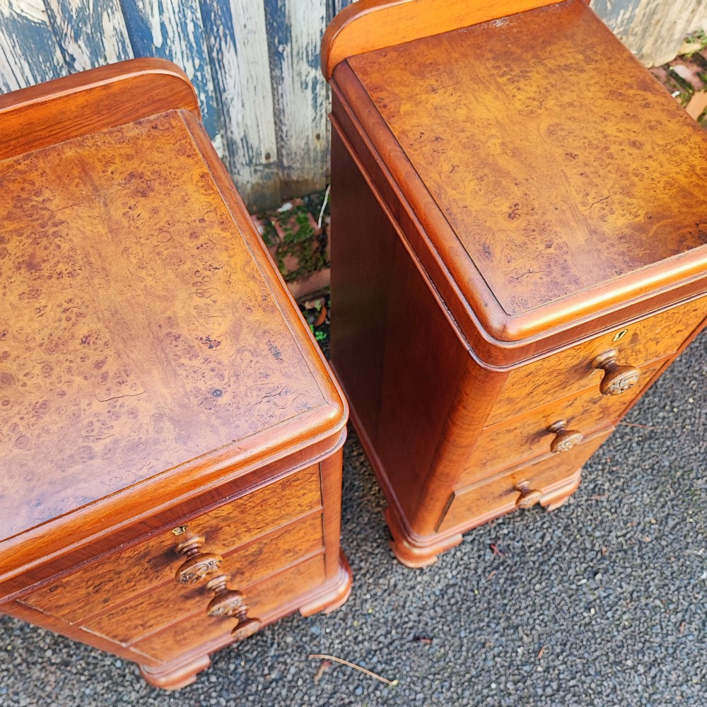 A pair of matching Art Deco burr walnut bedside cabinets featuring three drawers with carved wooden handles and a low raised gallery top. View III