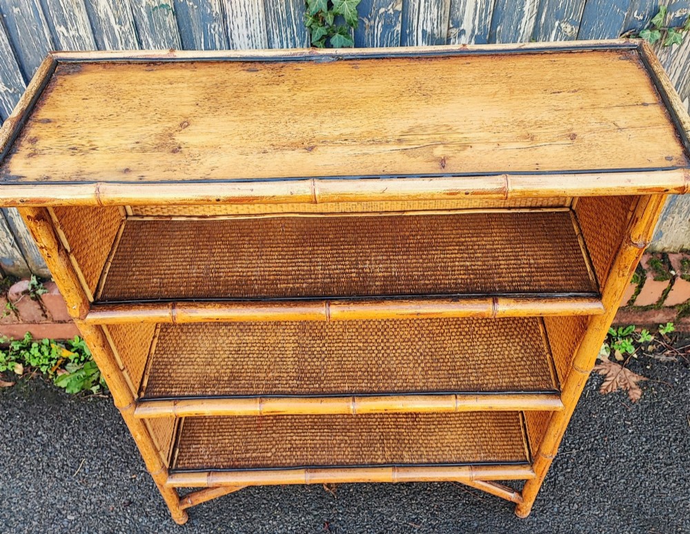 A late Victorian open bookcase featuring a bamboo cane frame, pine side panels, and three woven cane display shelves. View III