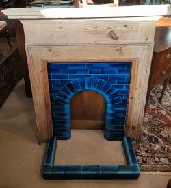 AN ANTIQUE PINE FIREPLACE AND SURROUND