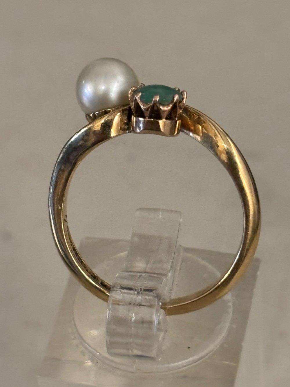 A yellow gold bypass ring featuring a round white cultured pearl alongside a claw-set green jade cabochon. View III